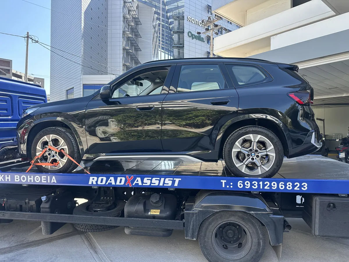 Μαύρο BMW X1 δεμένο με ιμάντες στους τροχούς πάνω στην πλατφόρμα