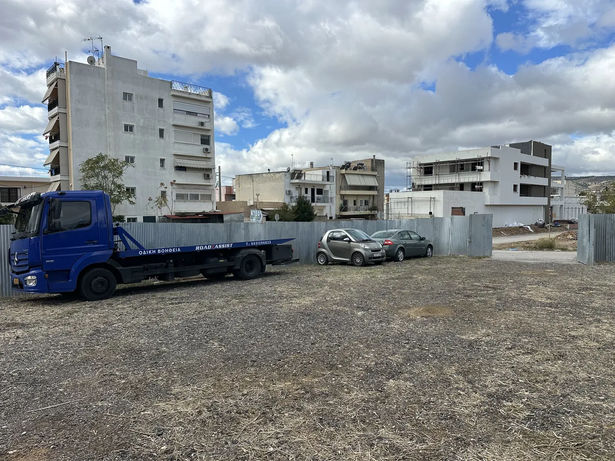 Ο περιφραγμένος χώρος φύλαξης με την πλατφόρμα και σταθμευμένα αυτοκίνητα